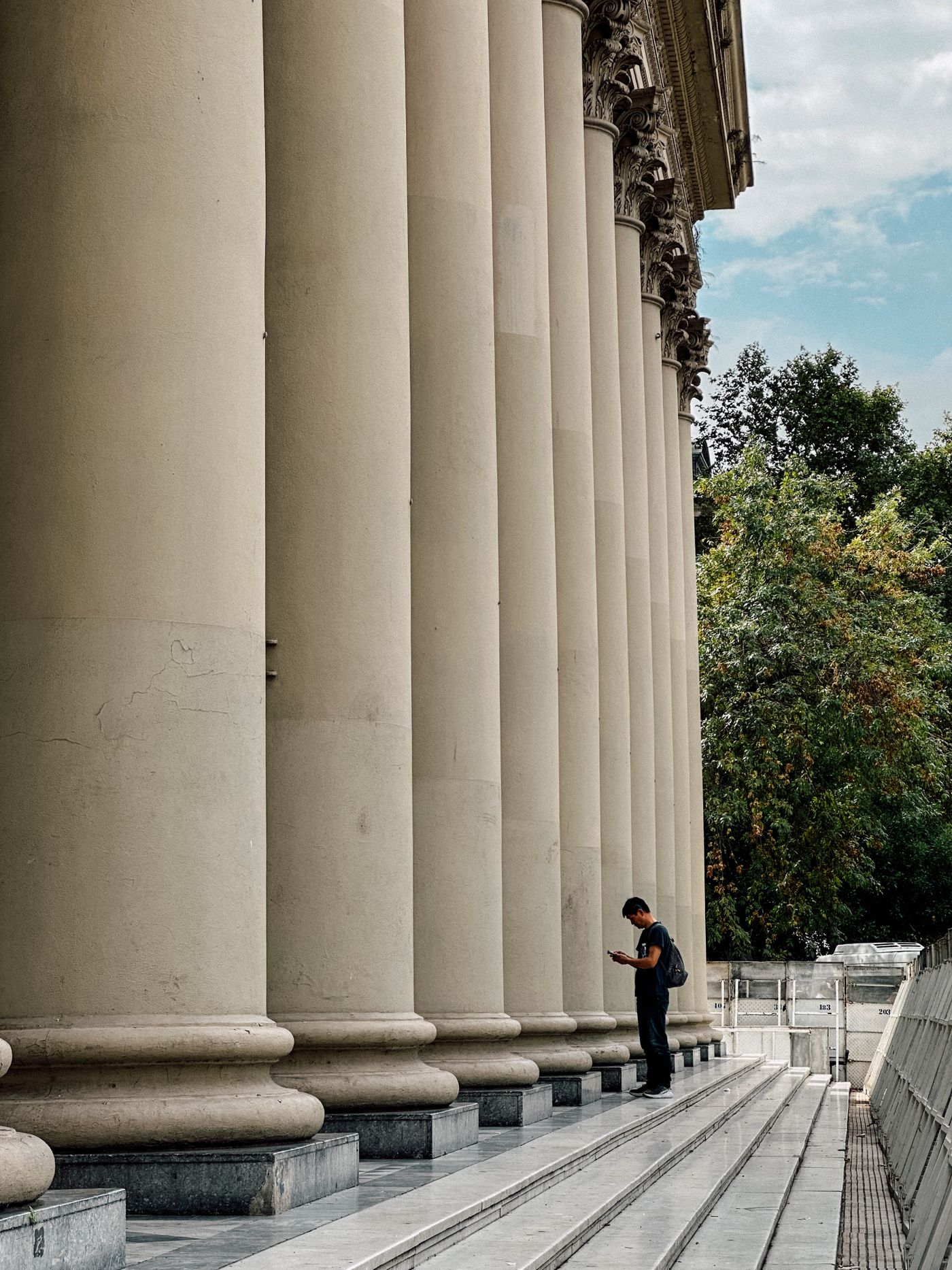 Figure walking past a grand government colonnade